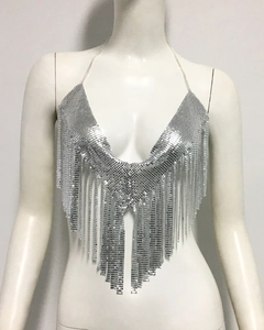Détail d'un top à paillettes argentées avec franges métalliques et chaînes licou