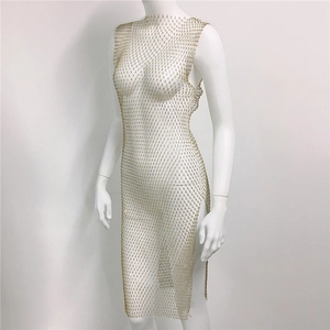 Détail de la robe en maille dorée avec strass, fente latérale et cristaux étincelants