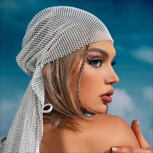 Close-up of sparkling rhinestone mesh headscarf with draped detail against blue sky background