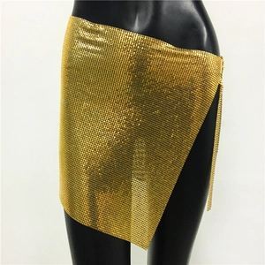 Detailed macro view of the gold metal mesh sequins and asymmetric hemline of the skirt