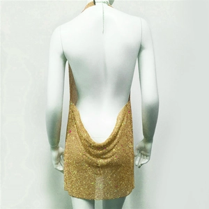 Close-up of golden sequin halter backless party dress on a mannequin with metallic shine