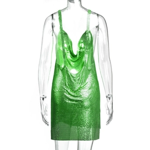 Dettaglio del tessuto a maglia metallica verde su un miniabito sexy con scollo a V