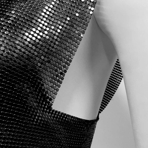 Detail of black metallic sequin mesh fabric showing hexagonal link texture and draping