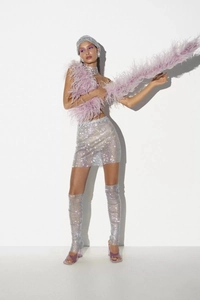 Détail de la mini-jupe en résille à strass argentés avec jambières assorties de fête