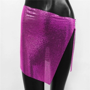 Detail of hot pink metallic mesh mini skirt featuring sequin chainmail and side straps