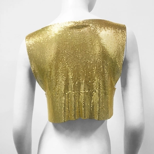 Close-up of golden sequin chainmail crop top with intricate metallic mesh texture