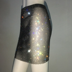Détail d'une mini-jupe en résille noire ornée de strass colorés denses et de gemmes