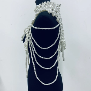 Close-up of multilayer pearl body chain with draped shawl design on black mannequin