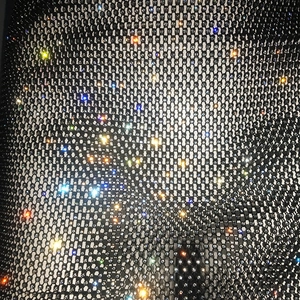 Gros plan de strass colorés haute densité sur le détail d'un tissu résille noir