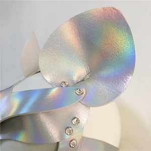Close-up of holographic leather texture with sparkling rhinestone studs detailing