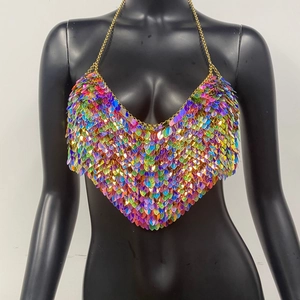 Détail de sequins irisés effet écailles et chaîne dorée sur une chaîne de corps licou