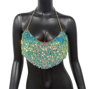 Détail de paillettes dégradées vert et bleu avec chaînes en métal doré sur le haut