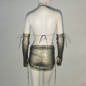 Dettaglio mini gonna in rete di strass argento e maniche con chiusura a lacci