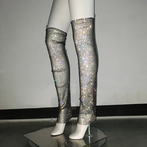 Détail de bottes cuissardes en résille argentée ornées de strass irisés scintillants