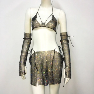 Dettaglio di strass colorati scintillanti su set bikini e minigonna in rete nera