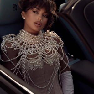 Luxurious vintage pearl body chain shawl with lace details worn by model in car