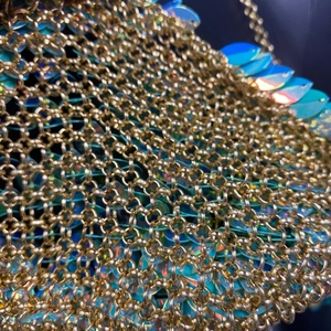 Vue détaillée des maillons dorés avec des paillettes bleues irisées scintillantes