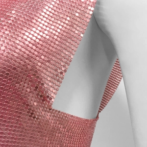 Close-up of pink metallic mesh fabric with hexagonal sequins on a mannequin