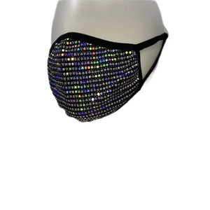 Détail d'un masque en tissu noir avec strass colorés sur une tête de mannequin blanche