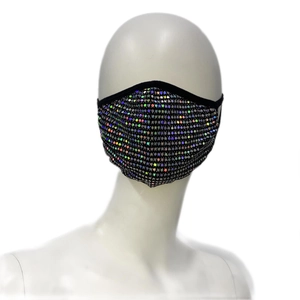 Détail du masque en tissu noir avec strass irisés sur un mannequin de tête blanc