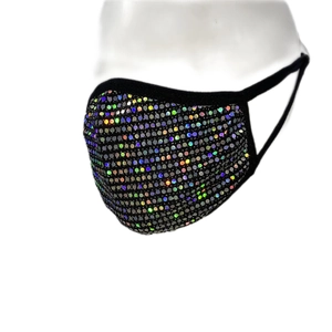 Gros plan du masque noir élégant avec paillettes irisées et boucles d'oreilles souples