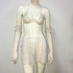 Dettaglio del set in rete con strass bianchi, reggiseno allacciato e gonna