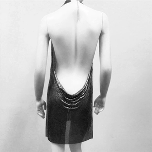 Détail d'une robe dos nu en maille métallique avec fines chaînes et sequins brillants