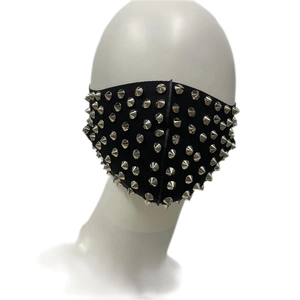 Détail d'un masque punk noir orné de rivets métalliques argentés et de clous coniques
