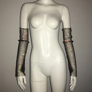 Détail de longs manchons en résille avec strass scintillants sur un mannequin blanc exposé