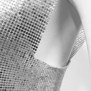 Detailed macro shot of a metallic sequin vest with hexagonal mesh chainmail texture
