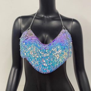Vue détaillée des paillettes laser colorées et des chaînes métalliques sur un top de fête