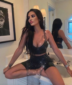 Close-up of the sparkling rhinestones on the mesh fabric of a sexy black mini dress