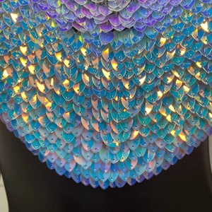 Détail macro de paillettes irisées en forme d'écailles sur un top dos nu sexy pour femme