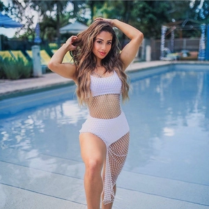 Detail of white rhinestone fishnet cover-up over a two-piece bikini by a sunny pool