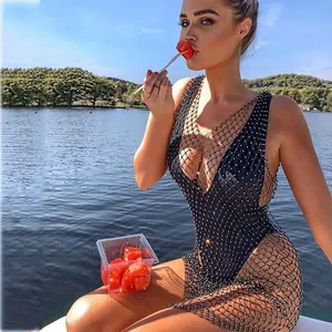 Detail of sheer black fishnet maxi dress with sparkling rhinestones over a swimsuit