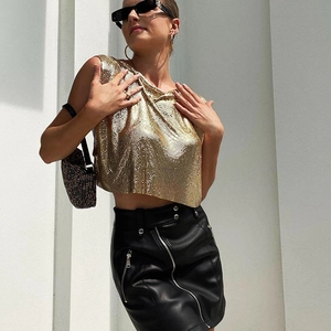 Sexy golden metallic sequin crop top paired with a black leather mini skirt for women