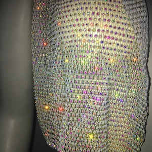 Gros plan sur un tissu en maille de strass étincelant avec reflets colorés pour la fête