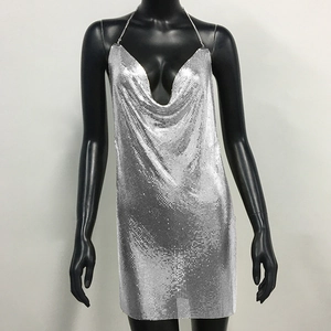 Detail of silver metallic sequin mesh fabric with V-neckline and reflective finish