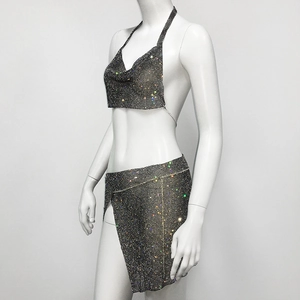 Detail view of sparkly rhinestone mesh on two-piece set with halter top and mini skirt