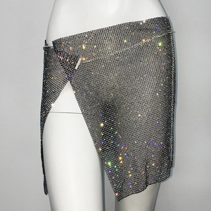 Close-up of asymmetric rhinestone party skirt with metallic mesh and side slit detail