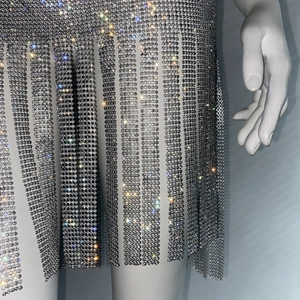 Détails macro des franges en strass argentés et du maillage métallique pour robe de fête