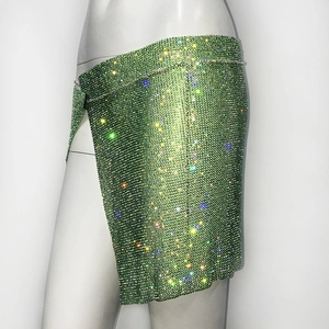 Détail de la jupe portefeuille verte en strass avec maille de cristal et fente latérale