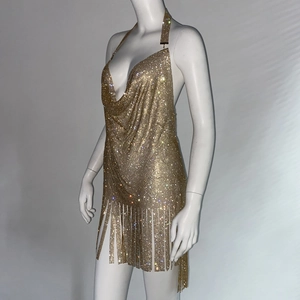 Détail d'une mini-robe dorée à strass et franges avec licou et maille métallique brillante