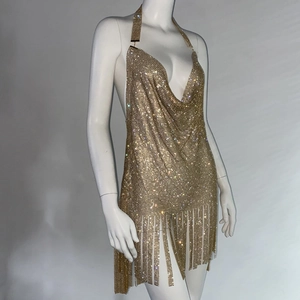 Détails macro du tissu en maille strass doré et ourlet à franges pour robe de soirée