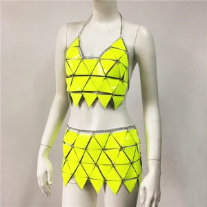 Détail d'un ensemble de festival vert néon avec chaînes métalliques et plaques géométriques
