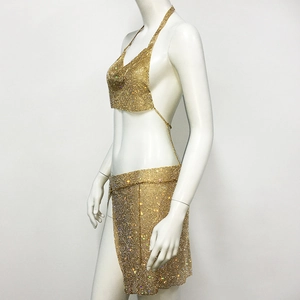 Detail of gold rhinestone mesh two-piece set featuring backless halter top and side slit skirt
