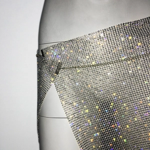 Détail d'une mini-jupe en maille de strass argentés avec fente latérale scintillante