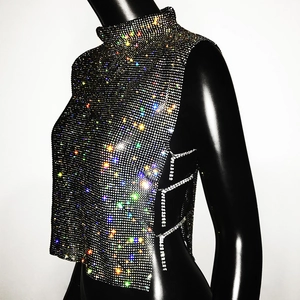 Macro detail of high-shine rhinestone mesh fabric and side cutout chains on party top