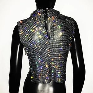 Macro detail of multicolored rhinestones on black mesh party top with metallic finish