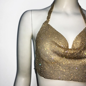 Detail of golden halter neck rhinestone top made of sparkling metal mesh fabric